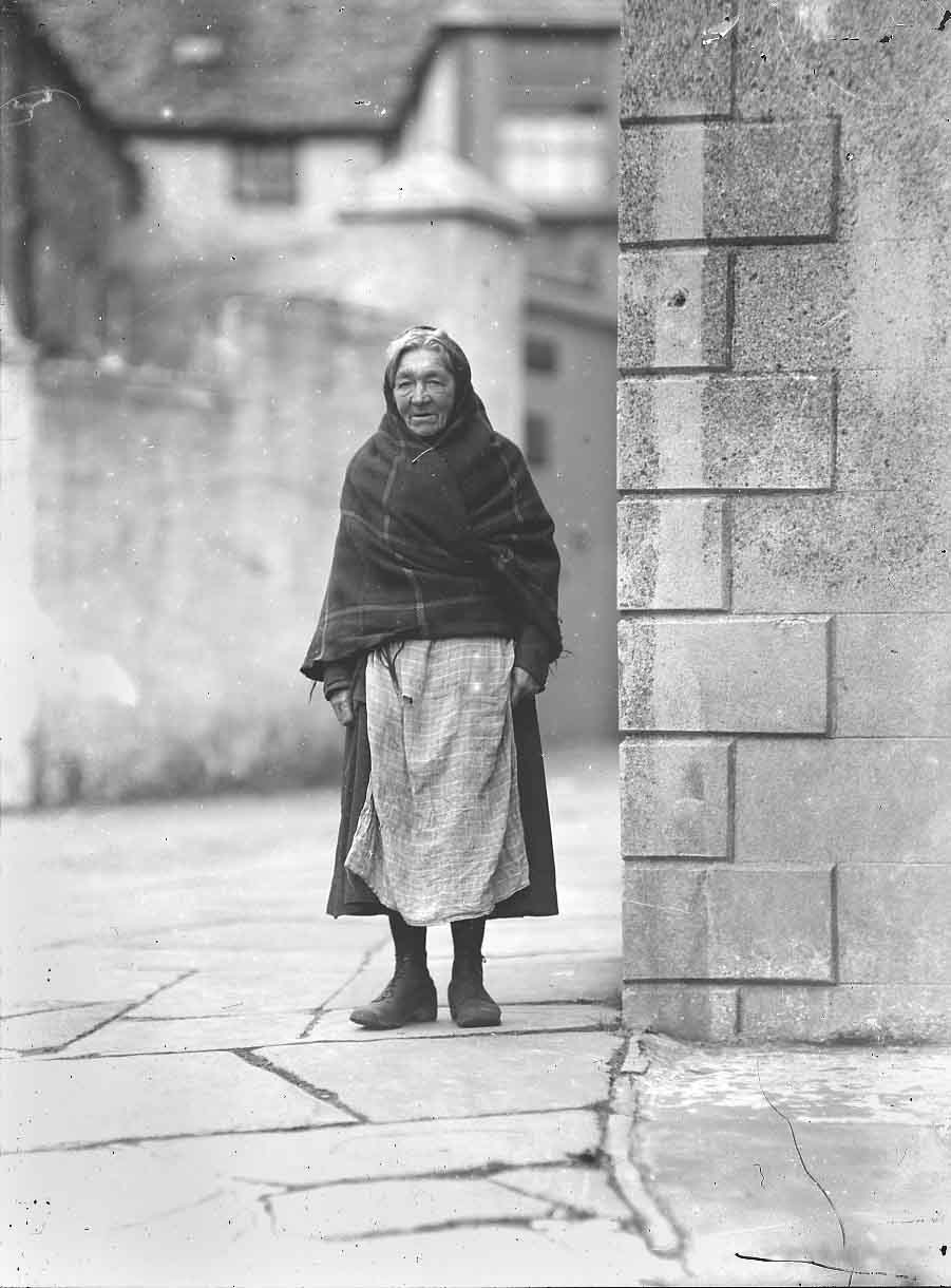 Black and white photo of Traveller Nellie Newlands walking down the street